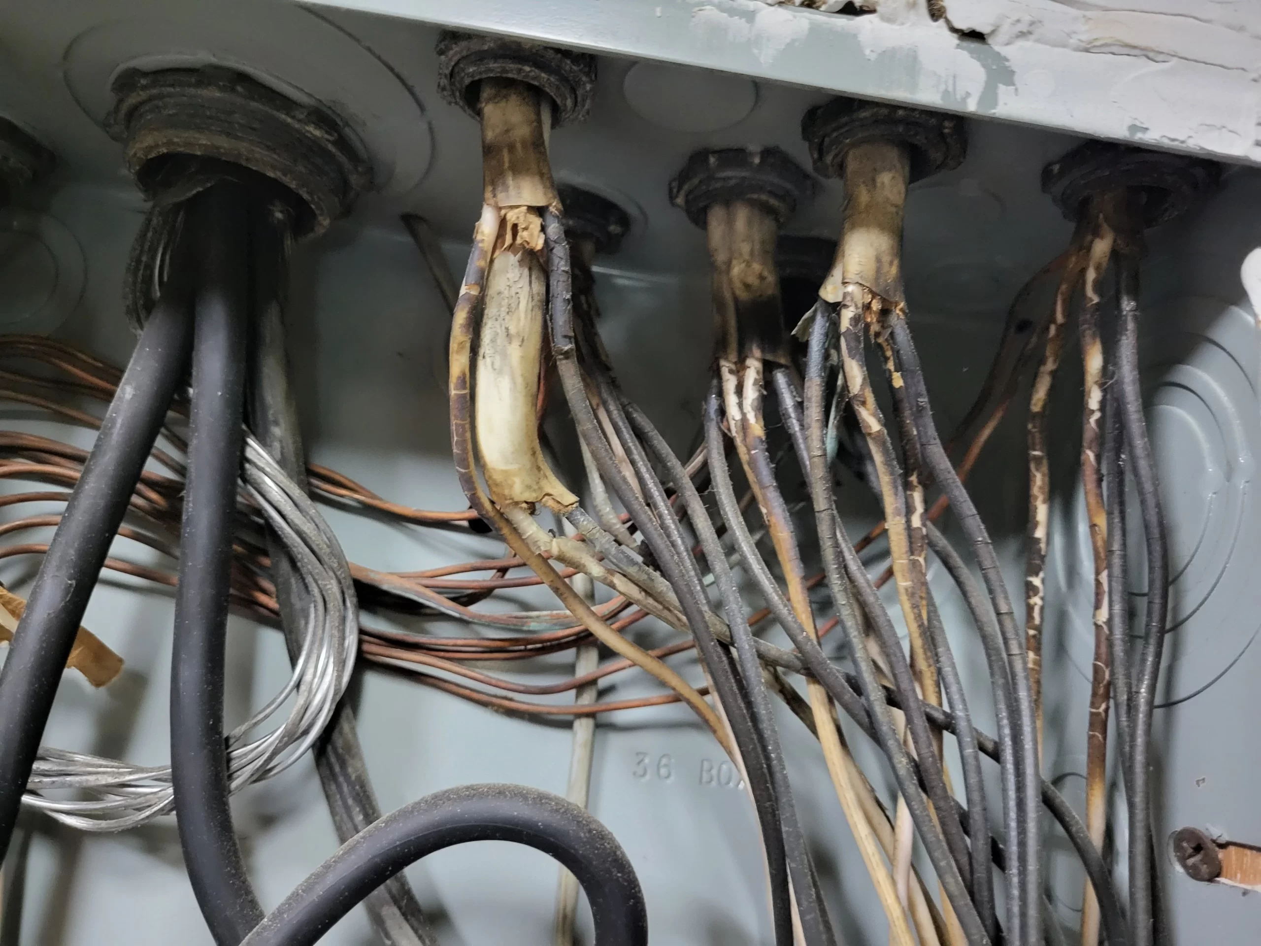 Empalme eléctrico deteriorado con cobre ennegrecido dentro de caja de registro