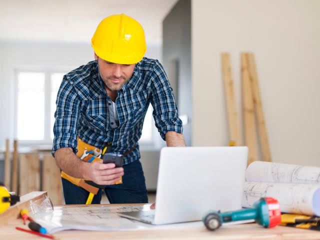 Operarios instalando tabiquería en obra de remodelación de espacio corporativo