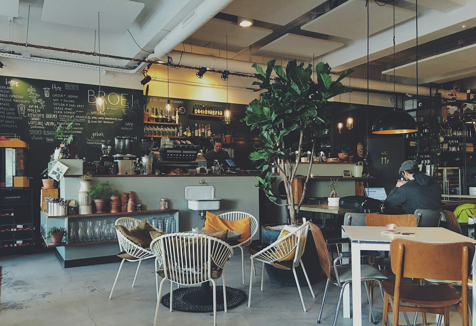 Cafetería terminada antes de la apertura con distribución de mesas y barra al fondo