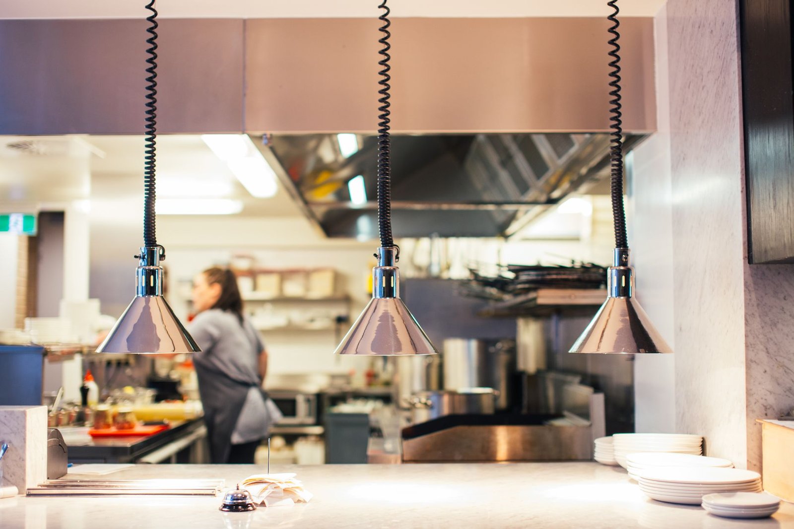 Cocina profesional con paredes lisas continuas junto a mobiliario de acero inoxidable