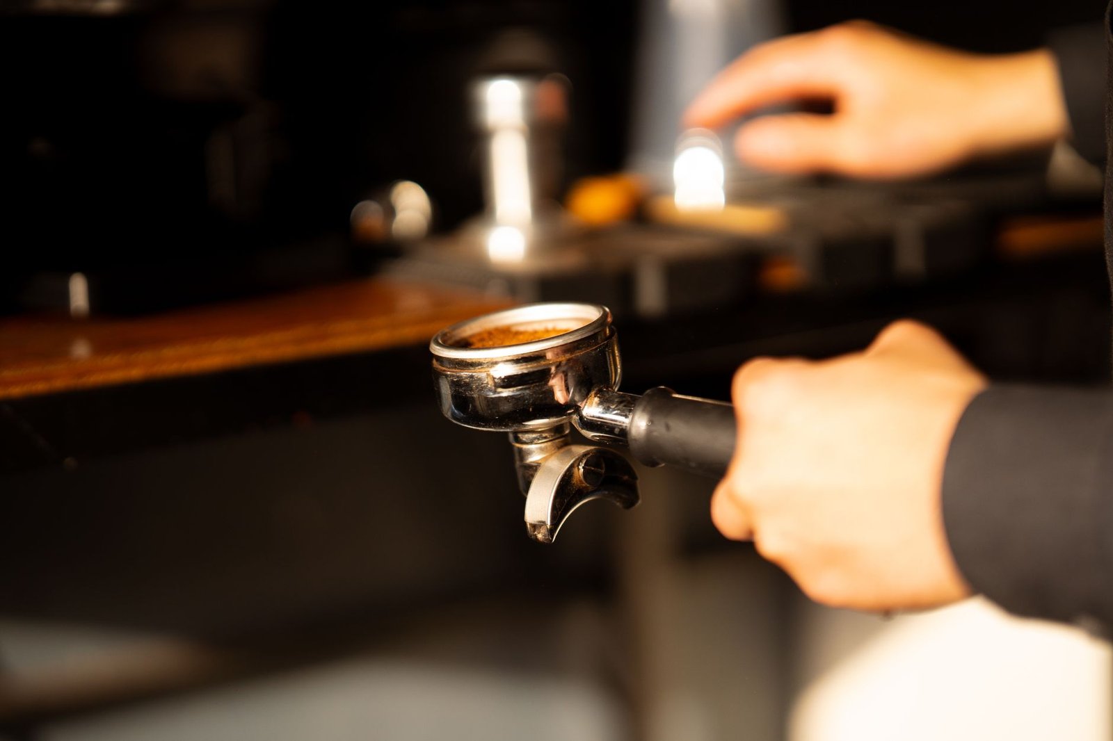 Barista dosificando café junto al molino en una barra bien distribuida