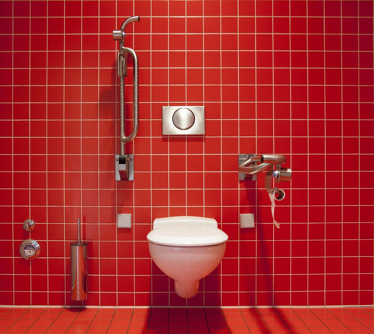 Baño adaptado con ducha enrasada, sumidero lineal y barra de apoyo lateral