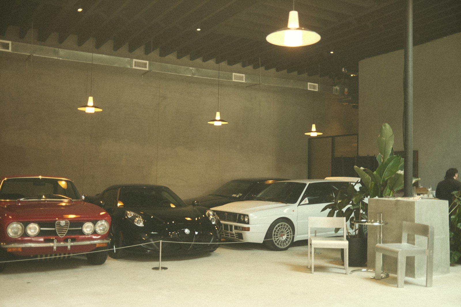 Sala de exposición de automóviles con fachada acristalada y pavimento continuo reformado