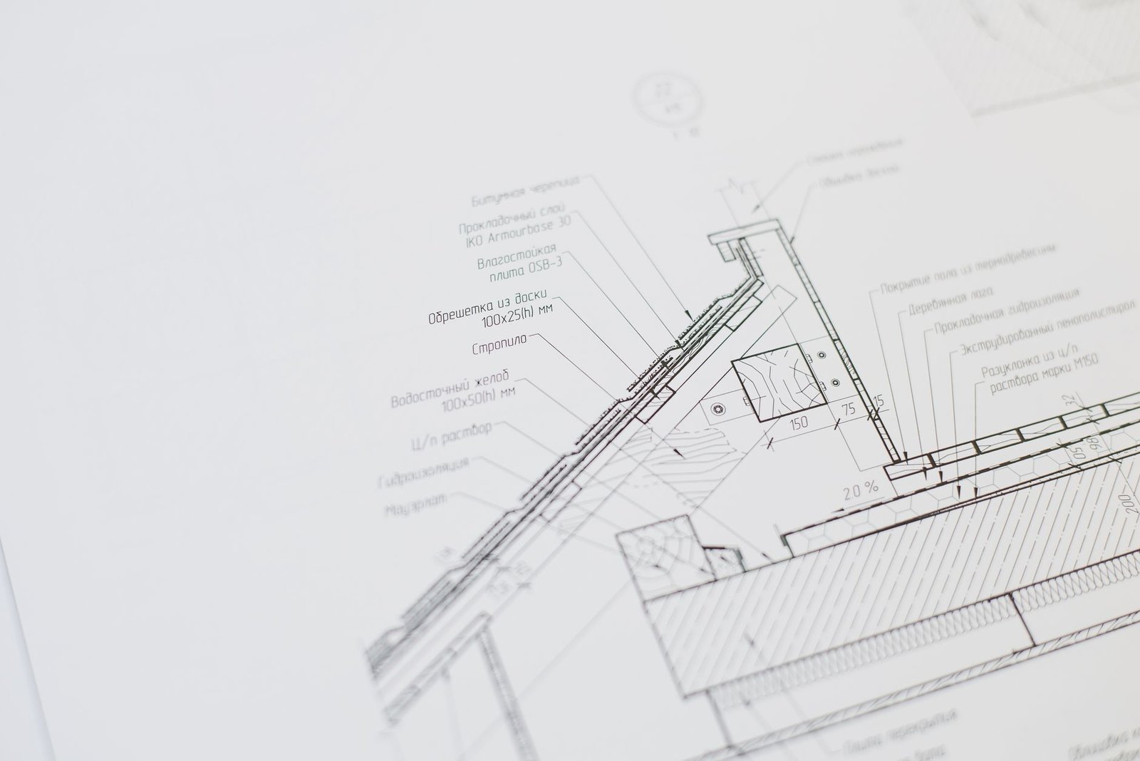 Plano de vivienda de dos plantas sobre mesa de trabajo con escalímetro