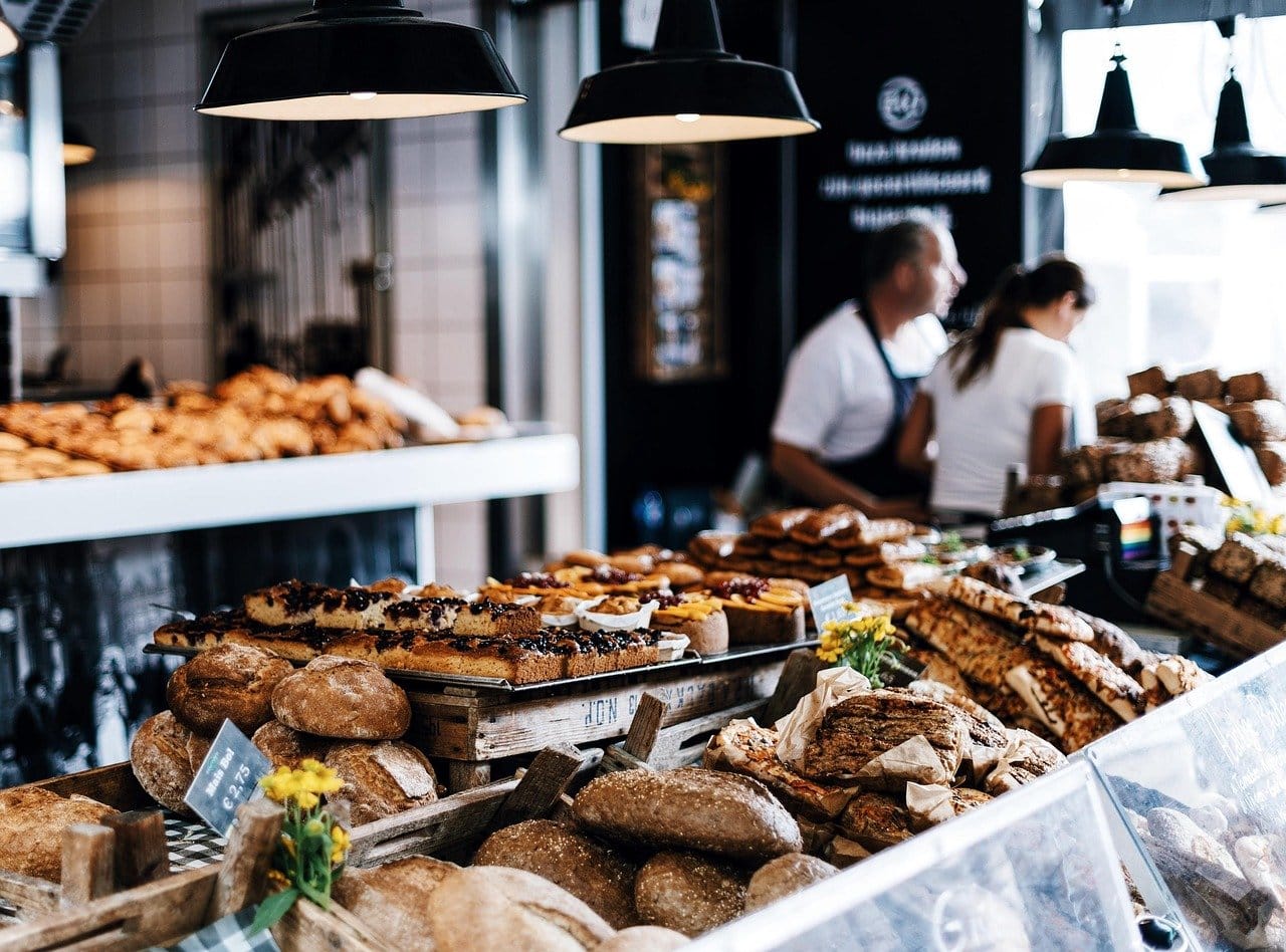Interior de pastelería con vitrina curva e iluminación cálida sobre el producto