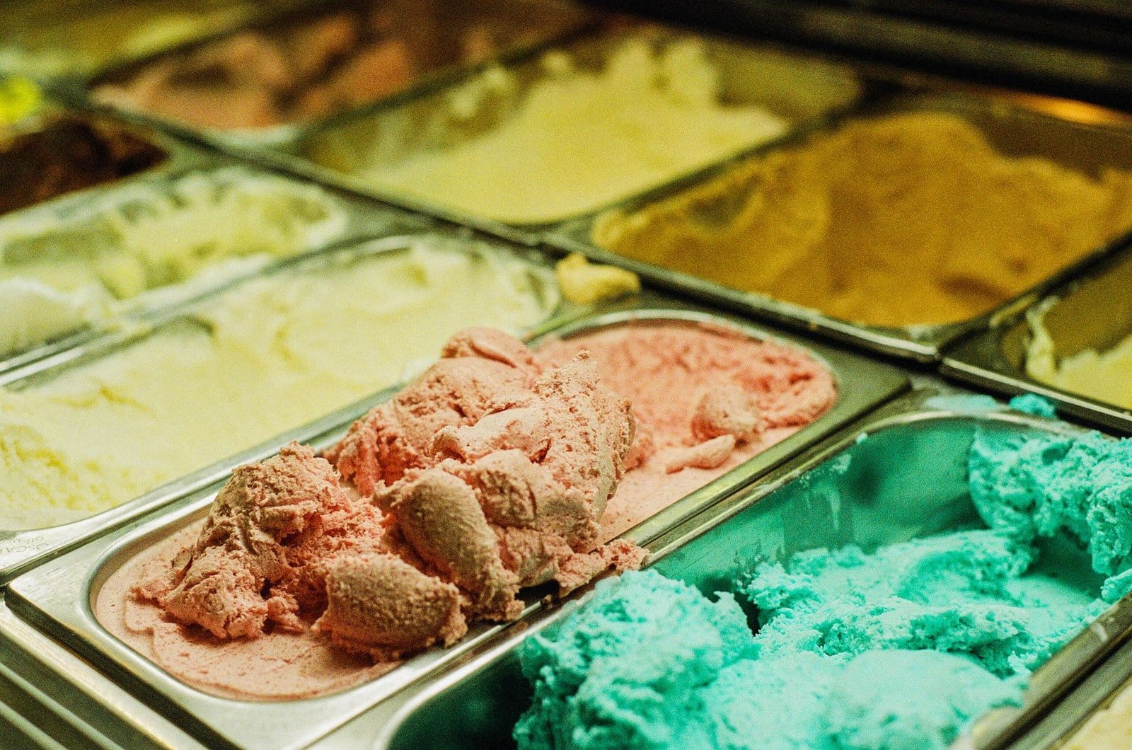 Vitrina de helado artesanal con cubetas metálicas en local reformado